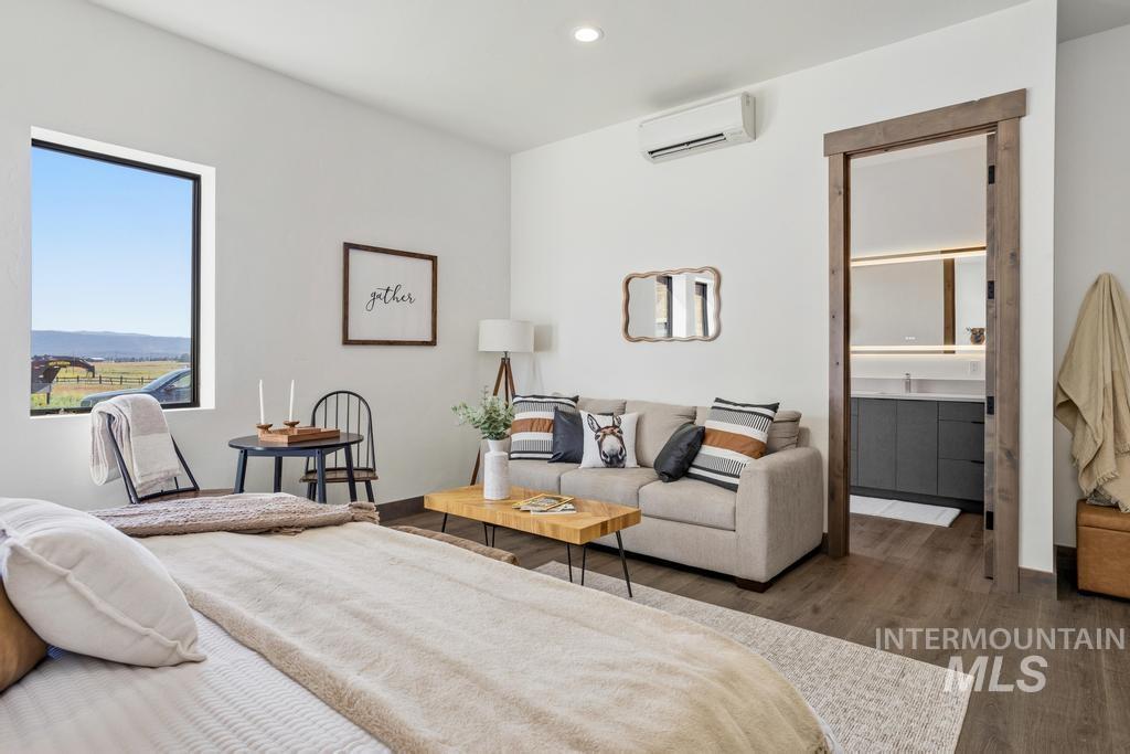 Spacious room featuring wood-finish flooring, a large window, and a split air conditioning unit