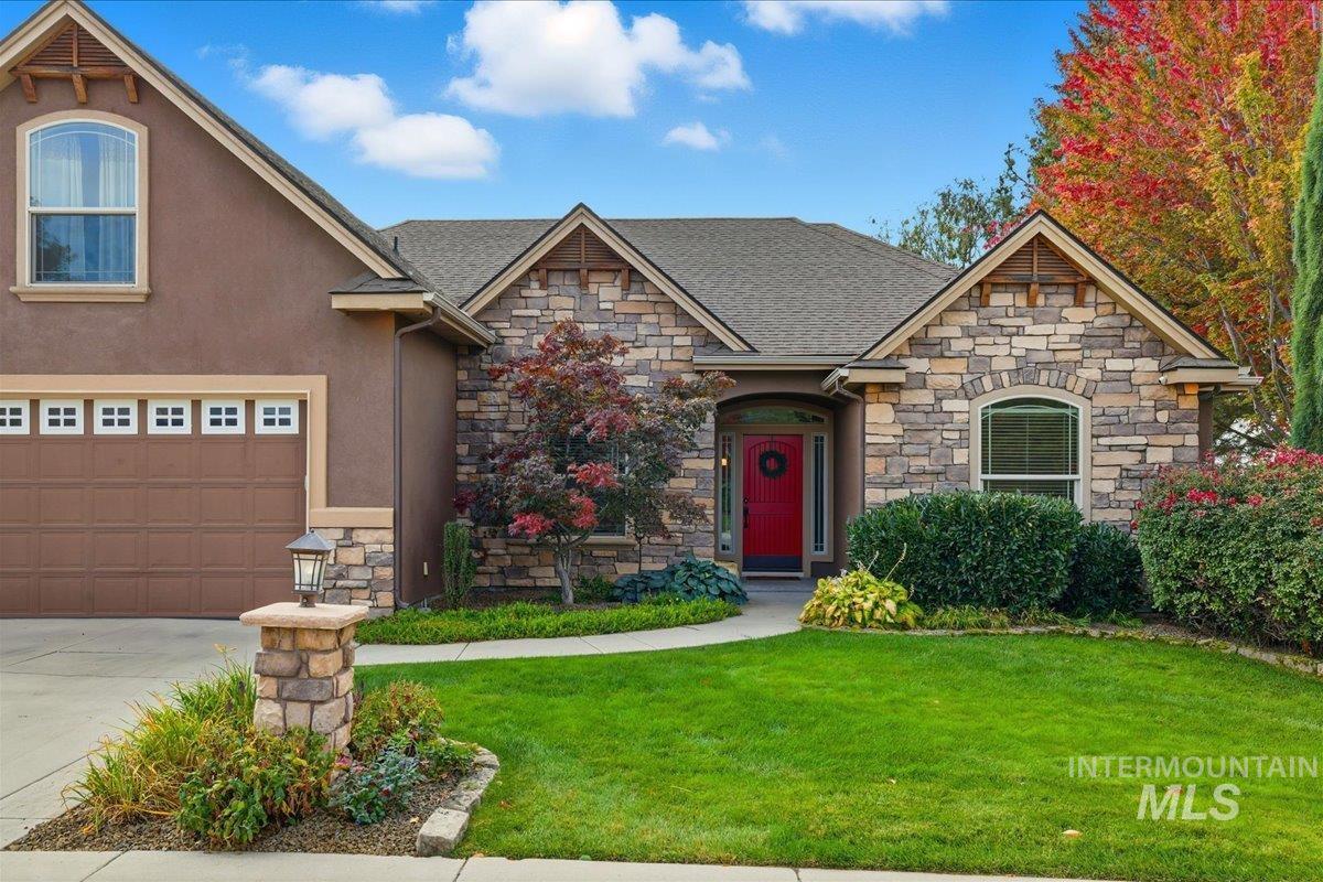 Craftsman inspired home with stone siding, a front lawn, concrete driveway, and a garage
