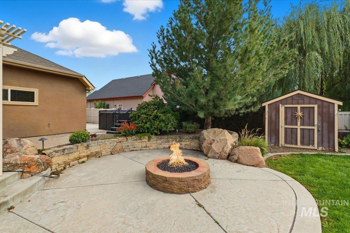 View of patio / terrace featuring a storage unit and a fire pit