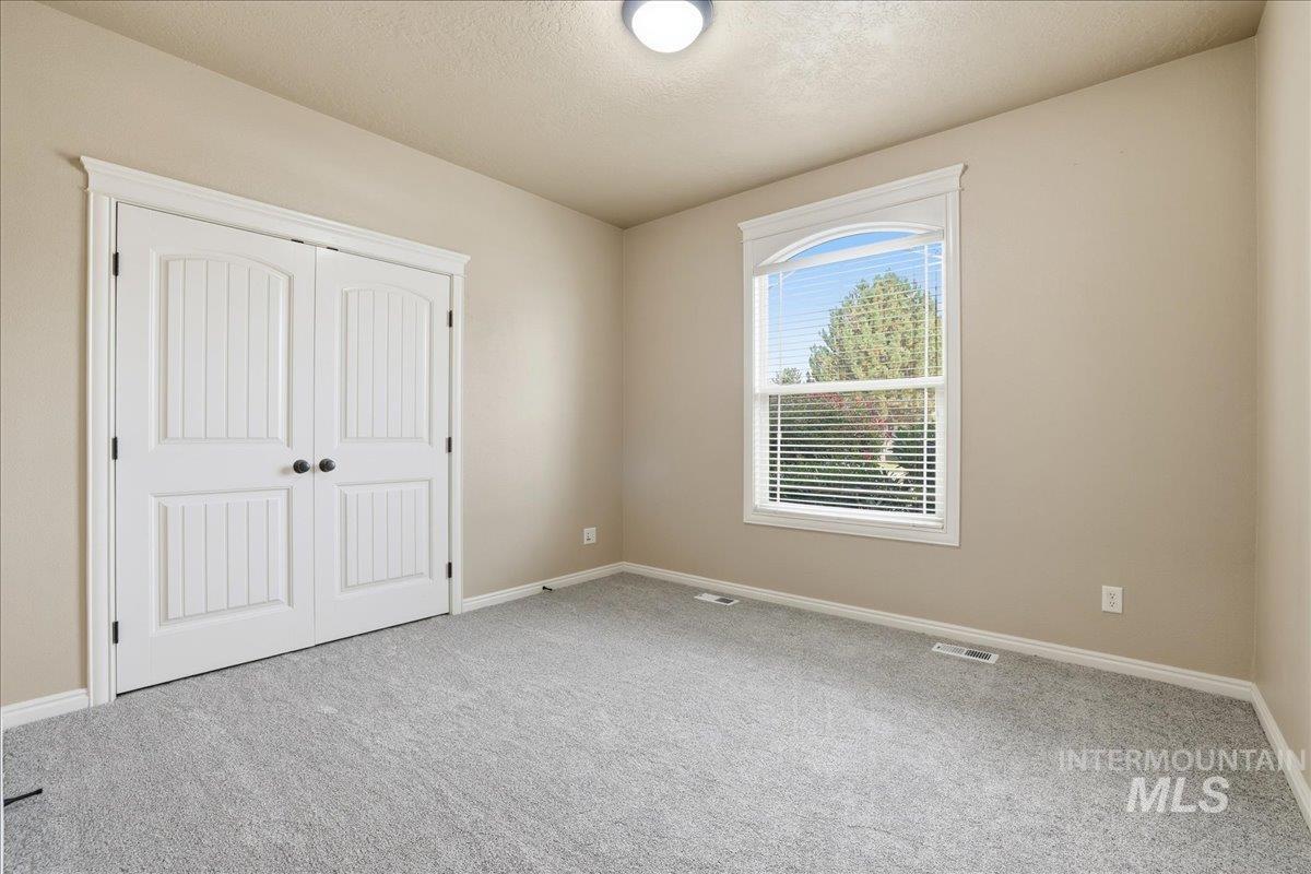 Unfurnished bedroom with a closet, carpet flooring, and a textured ceiling
