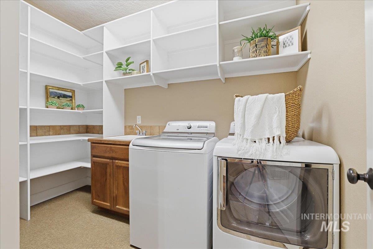 Laundry area with washing machine and clothes dryer and a sink