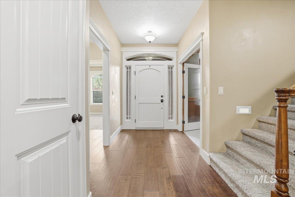 Entryway featuring wood finished floors, a textured ceiling, and stairway