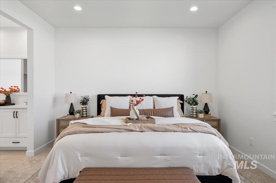 Bedroom with recessed lighting, light colored carpet, and connected bathroom