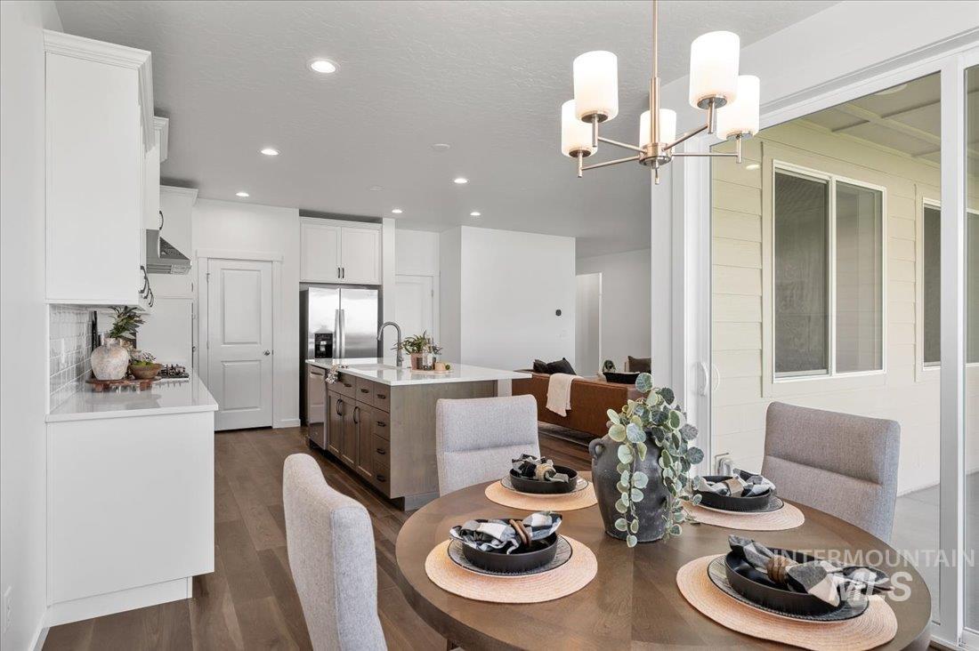 Dining space featuring dark wood-style flooring and hanging lights