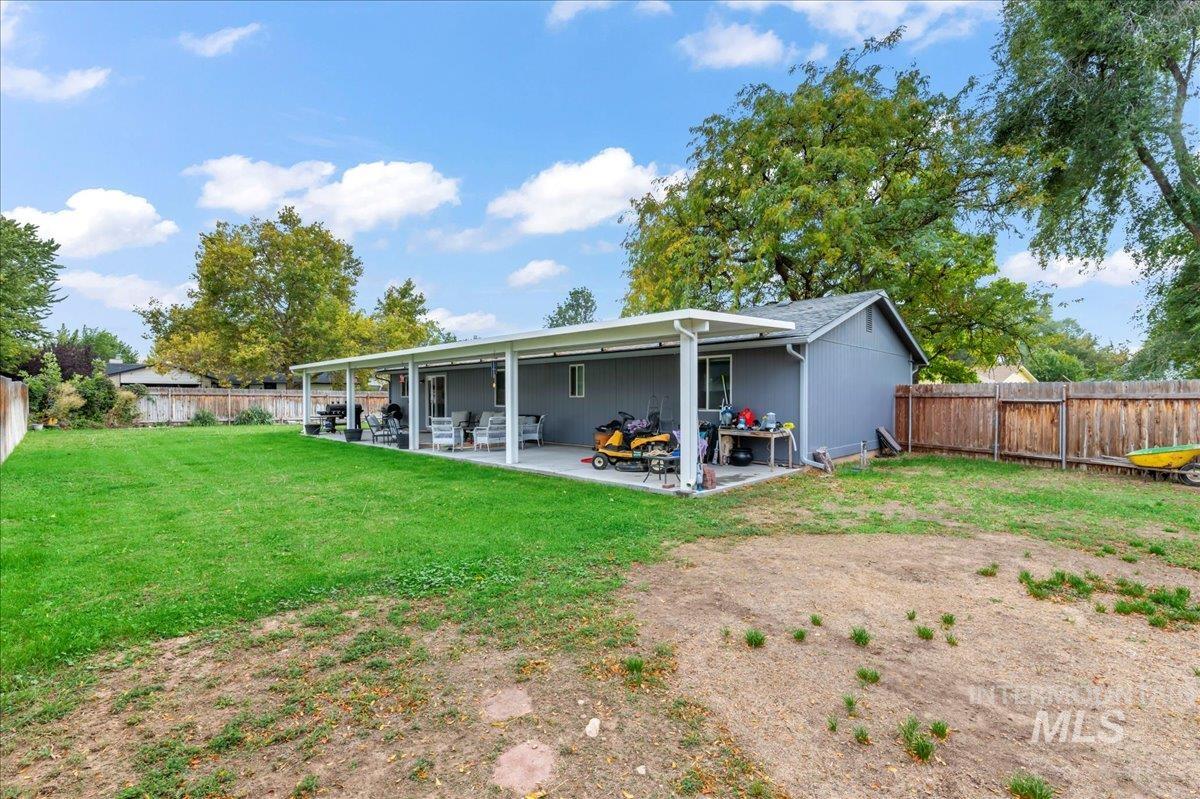 Back of house with a fenced backyard and a patio area