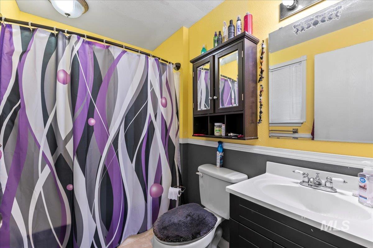 Full bath with vanity and a shower with shower curtain