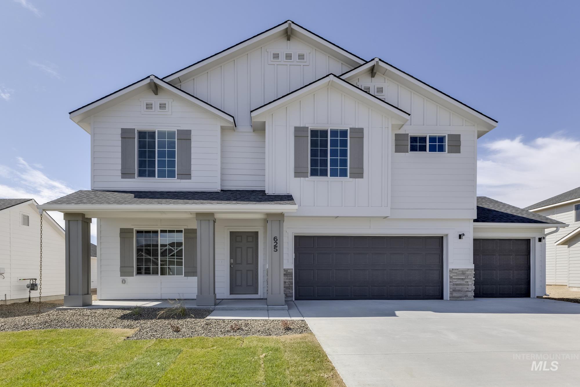 View of front facade with board and batten siding, concrete driveway, a garage, and stone siding