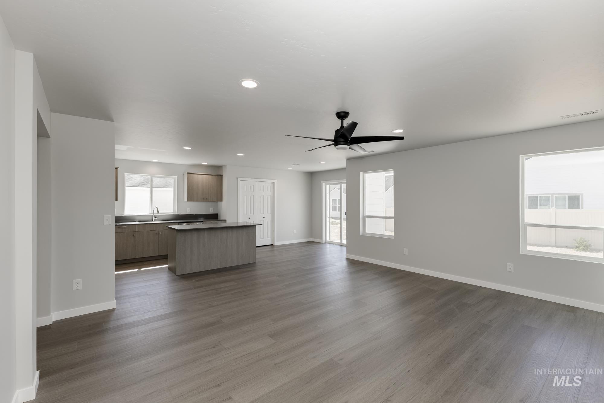 Unfurnished living room with ceiling fan, dark wood finished floors, and recessed lighting