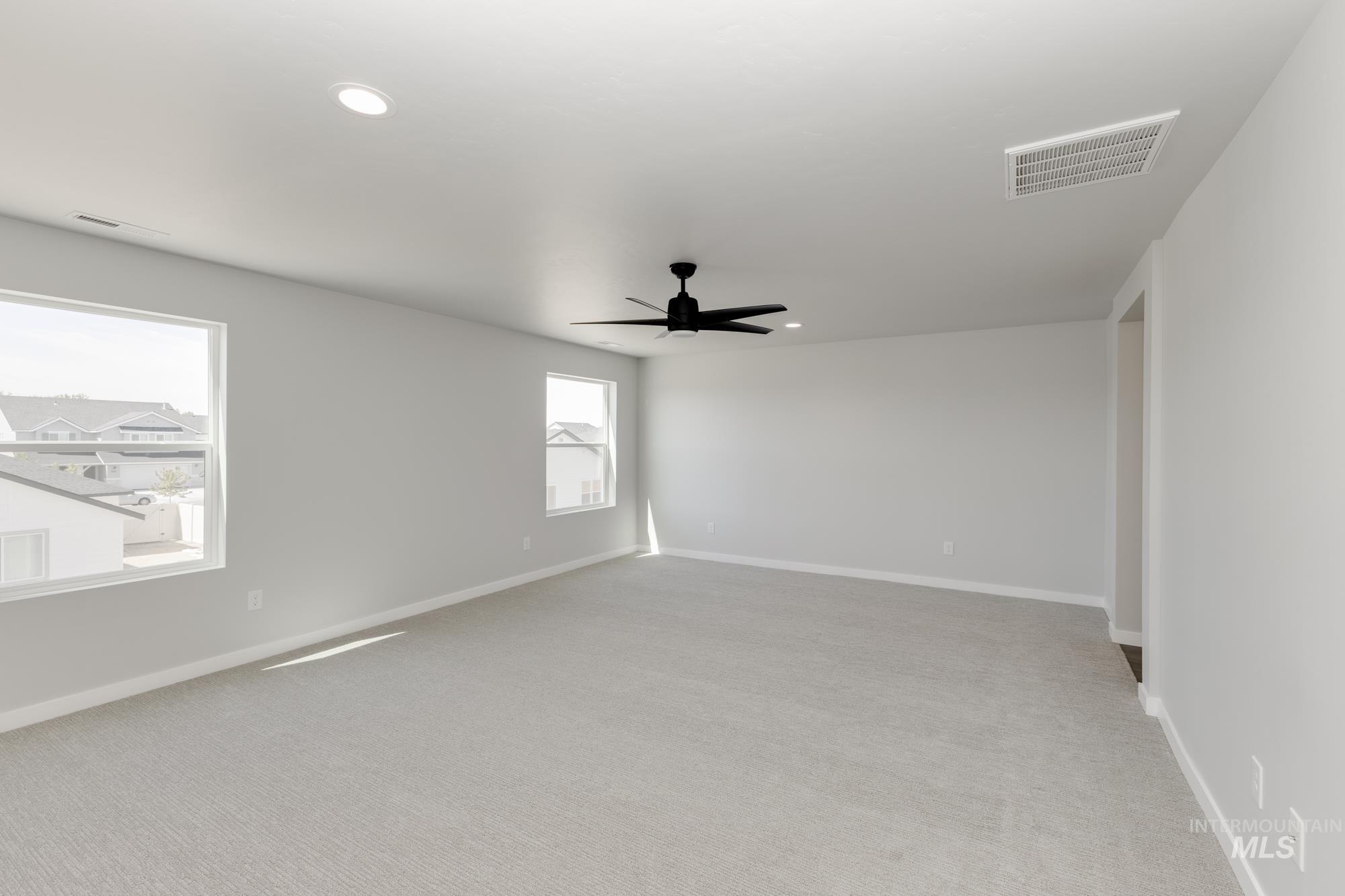 Spare room featuring recessed lighting, a ceiling fan, and light carpet