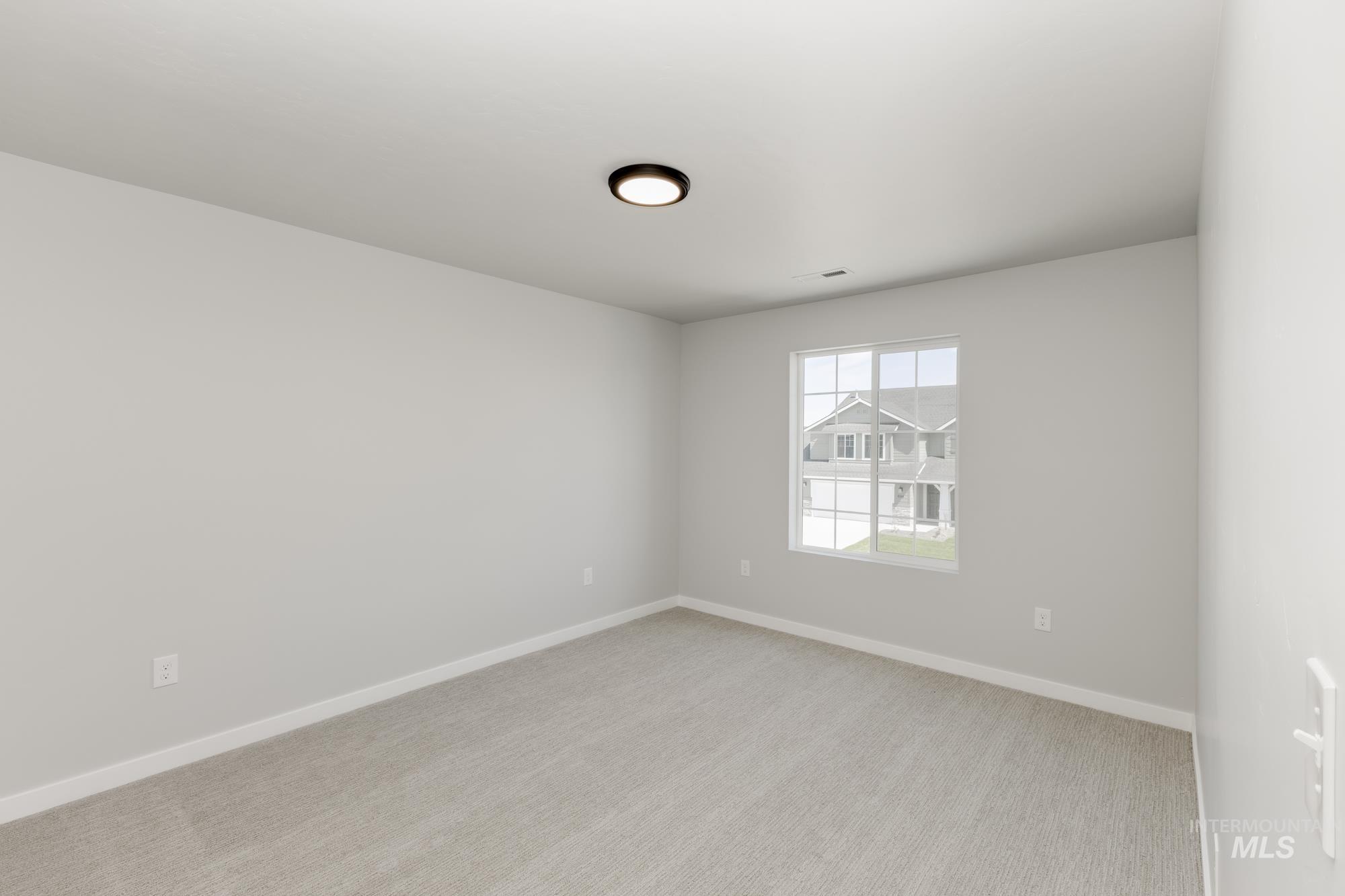 Spare room featuring light carpet and baseboards