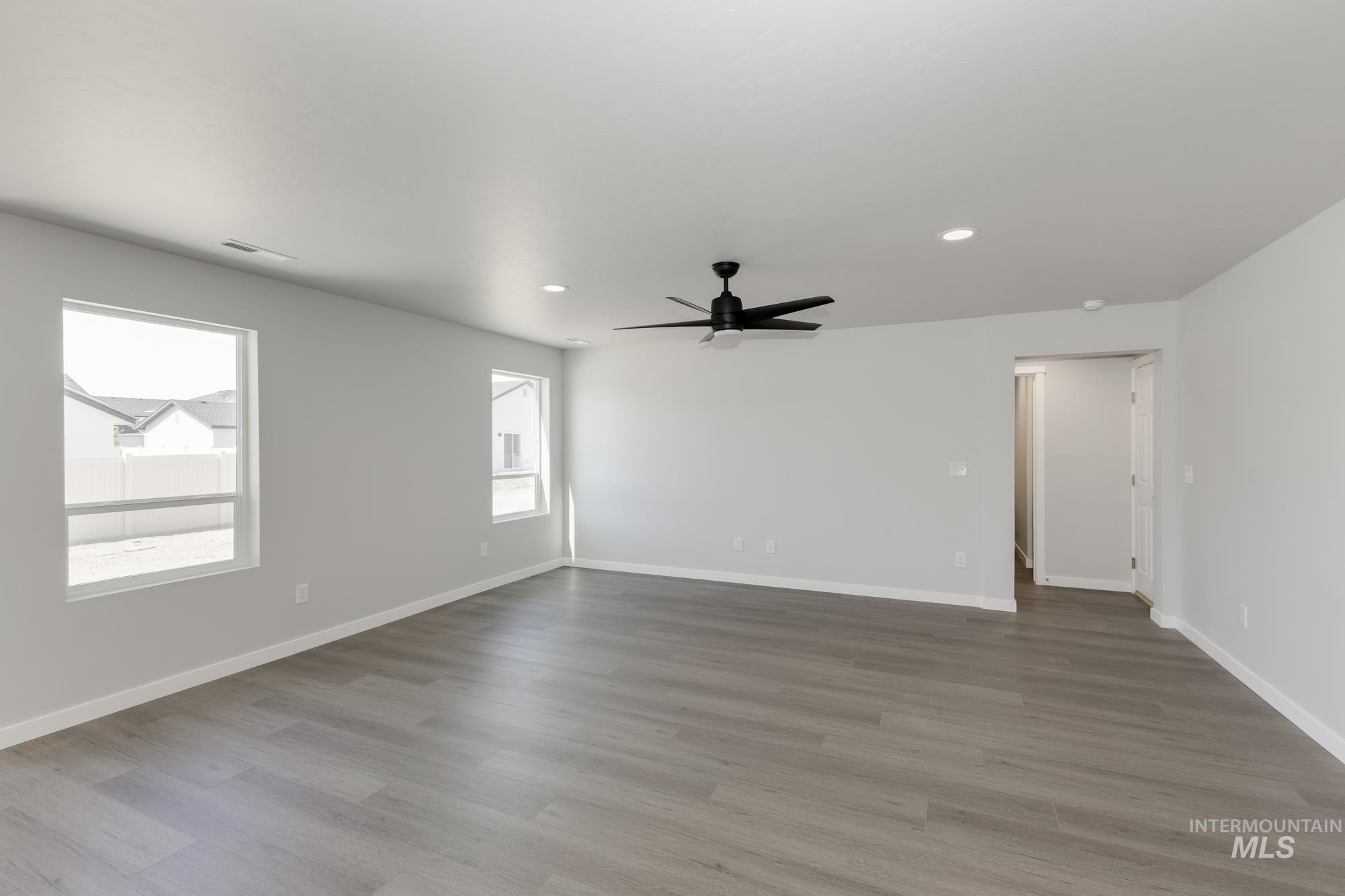 Empty room featuring plenty of natural light, ceiling fan, recessed lighting, and wood finished floors