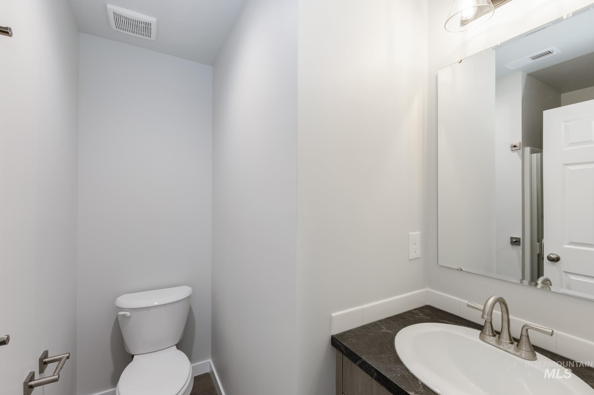 Half bath featuring toilet and vanity