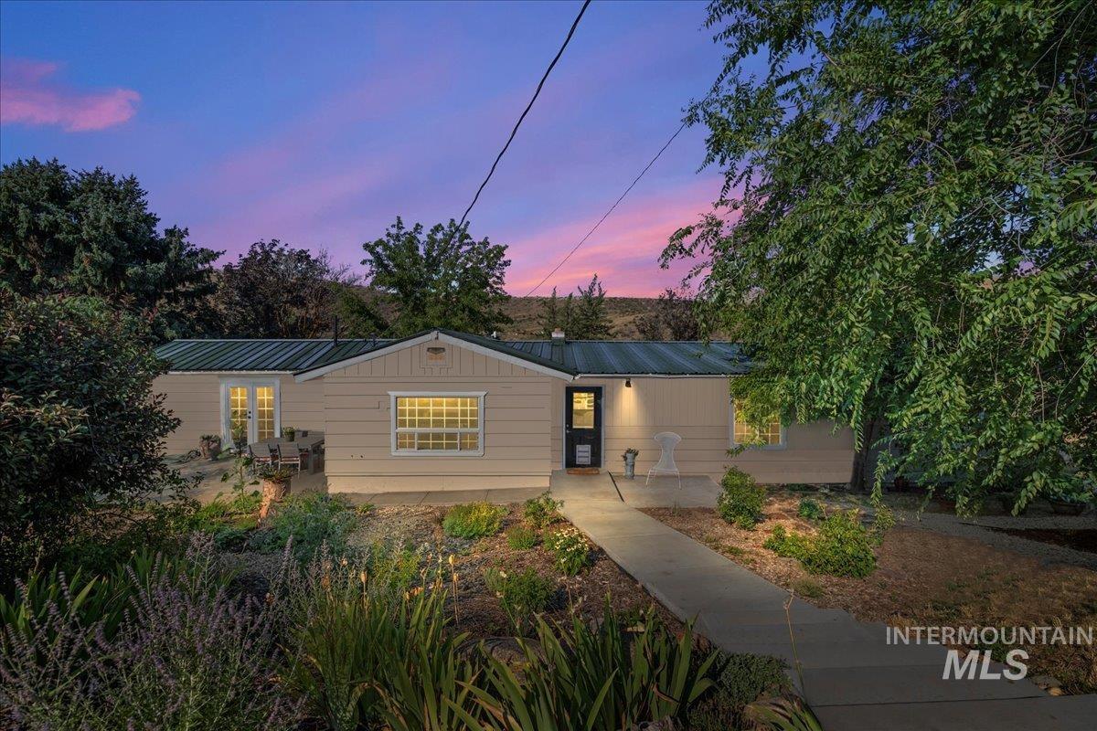 Single story home with a metal roof, french doors, and a patio.  This is the main entrance at the back of the home.  New concrete stairs and patio recently installed.