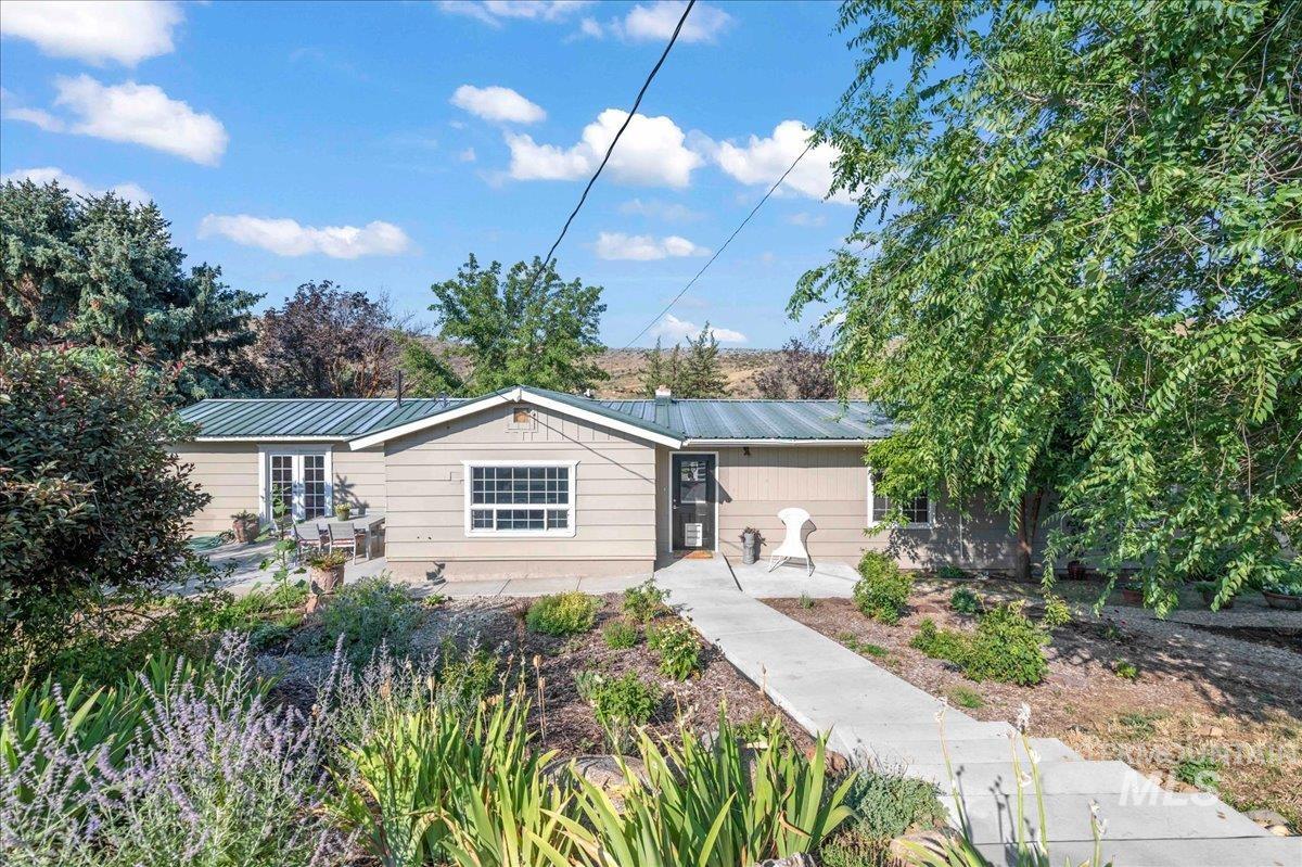 Single story home featuring a metal roof and a patio