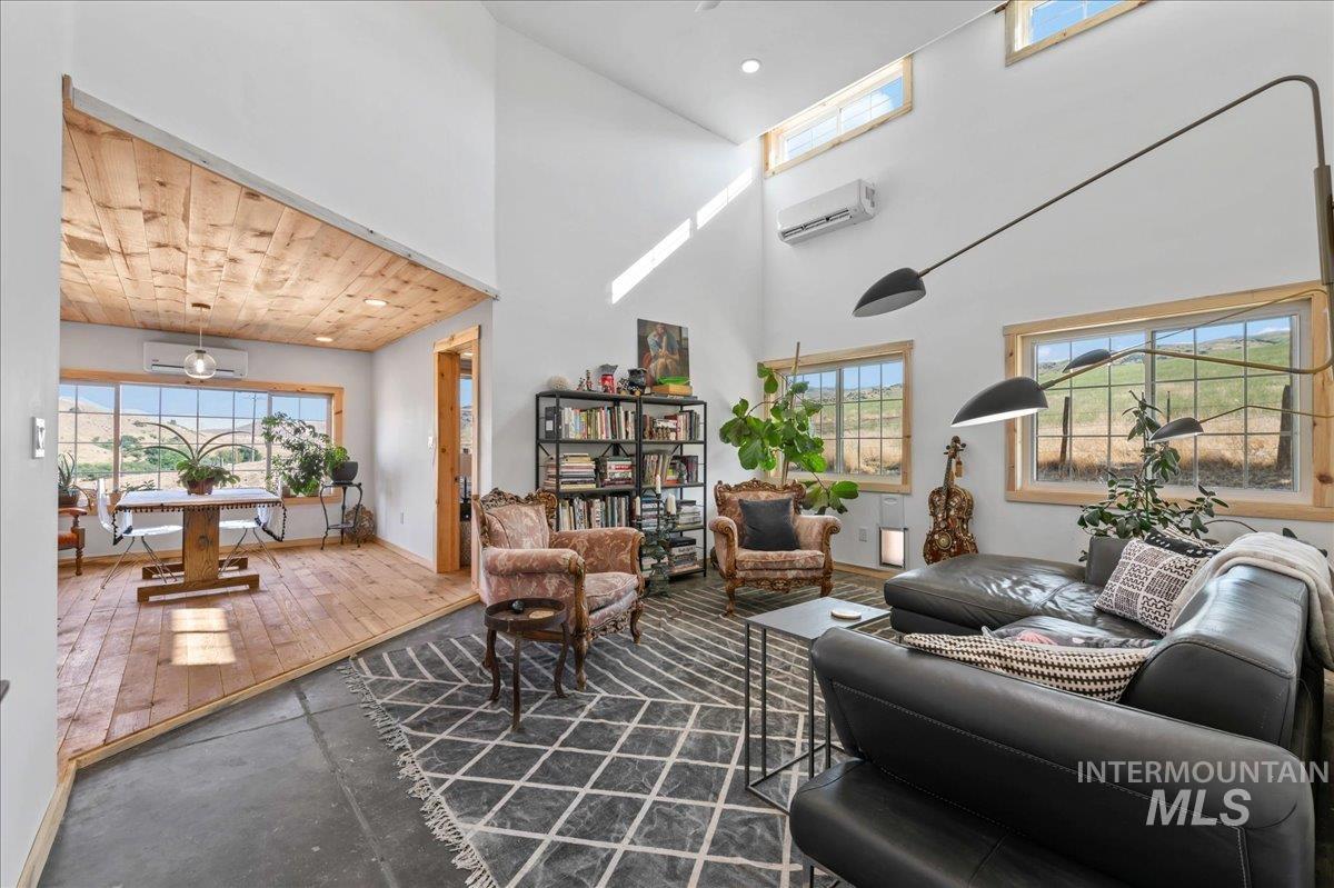 ADU living area featuring wooden ceiling, a high ceiling, recessed lighting, and a wall heat/ac mini split