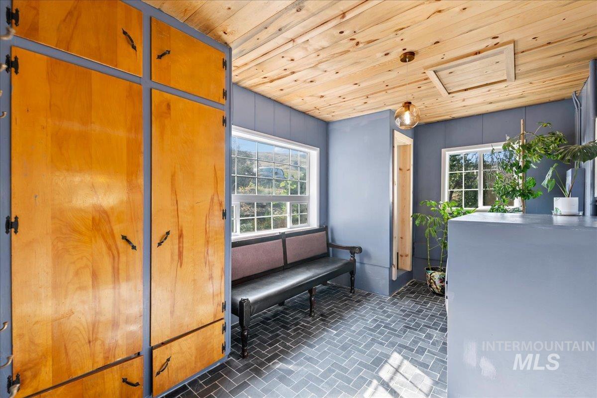 Mudroom with wood ceiling and new tile flooring.  Has a closet in the corner