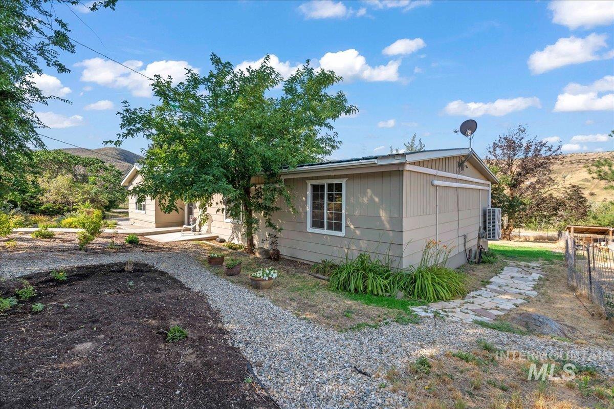 View of back side of house next to garden area and playhouse.