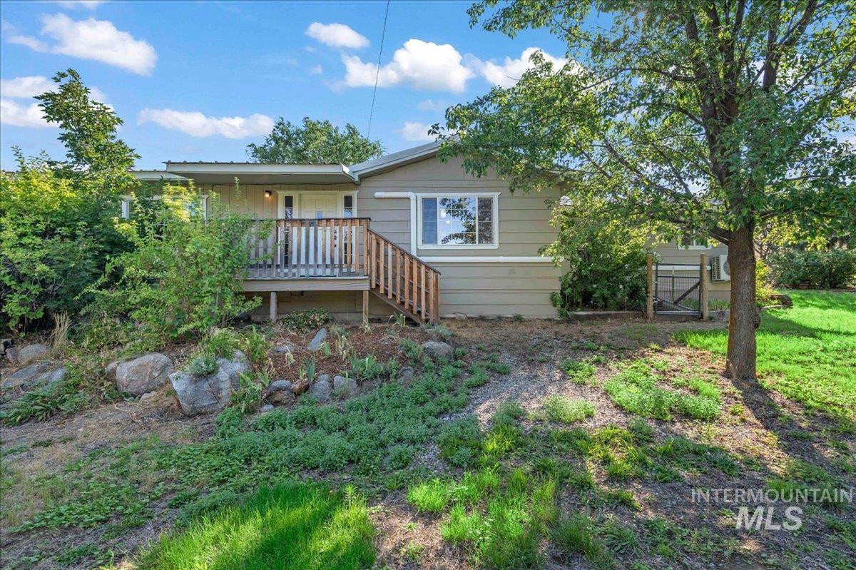 Front view of house featuring a deck.  The main entrance is at the back of the home where the parking is.