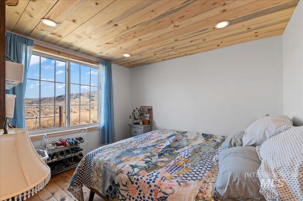 ADU main bedroom with hardwood flooring, recessed lighting, and wood ceiling.  The views are stunning.