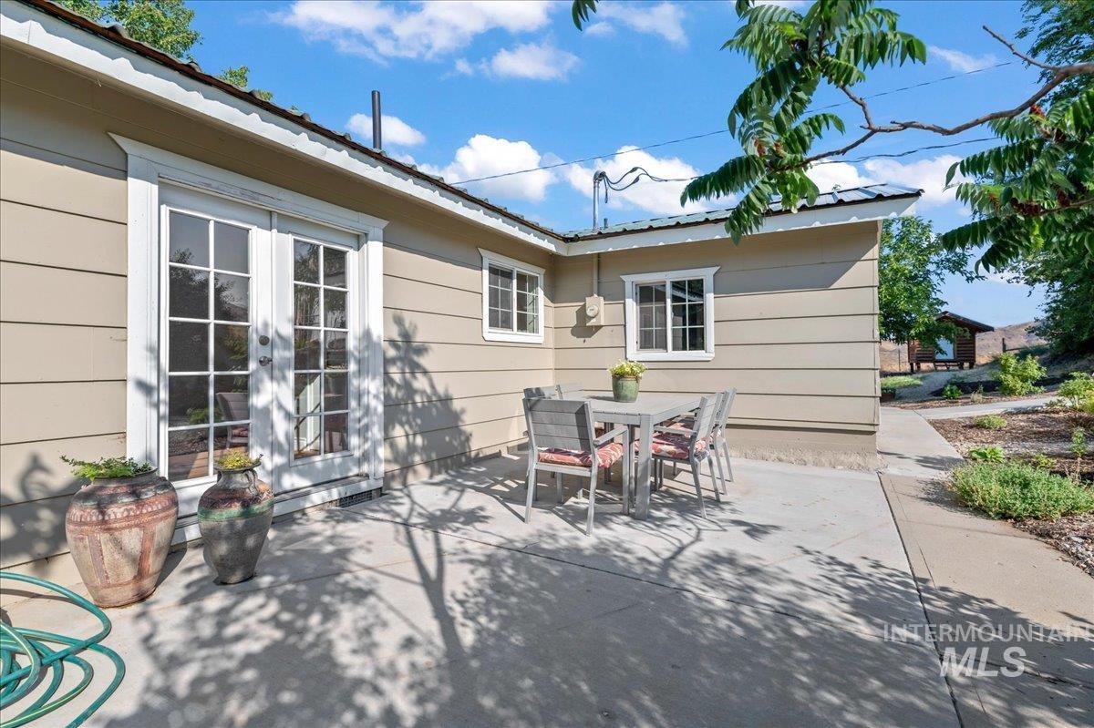 View of patio featuring outdoor dining area and french doors into the master bedroom