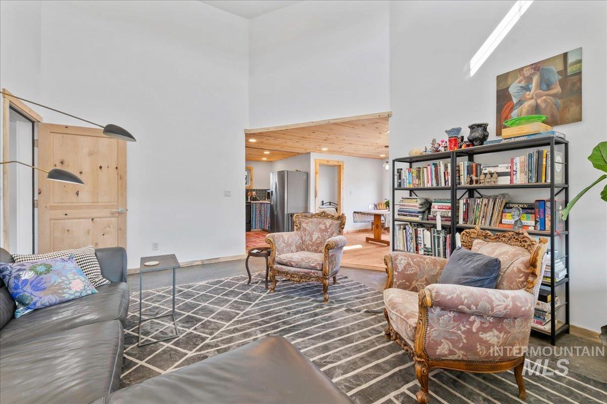 ADU living area with a high ceiling and view into dining area.
