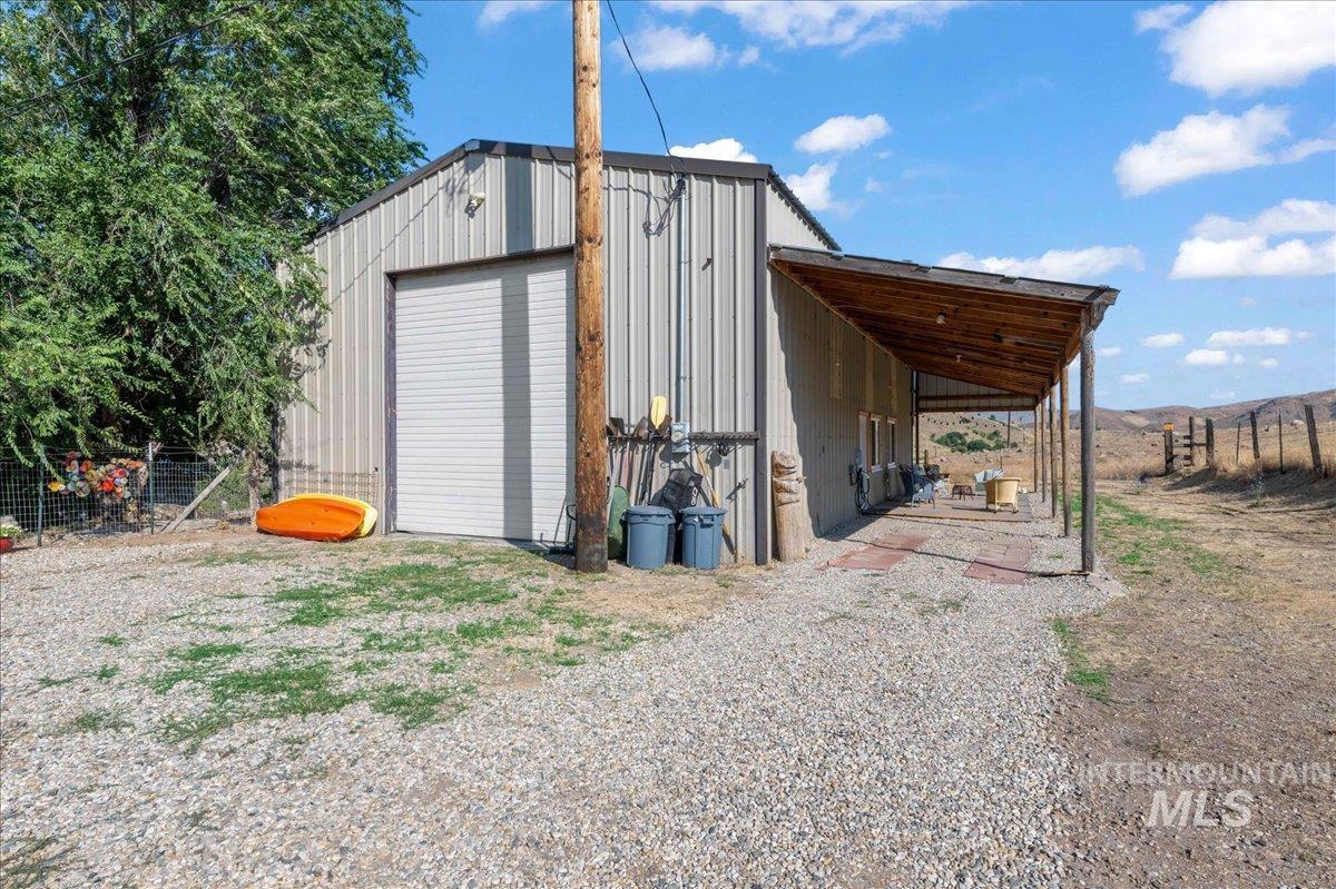 View of front of shop featuring gravel driveway