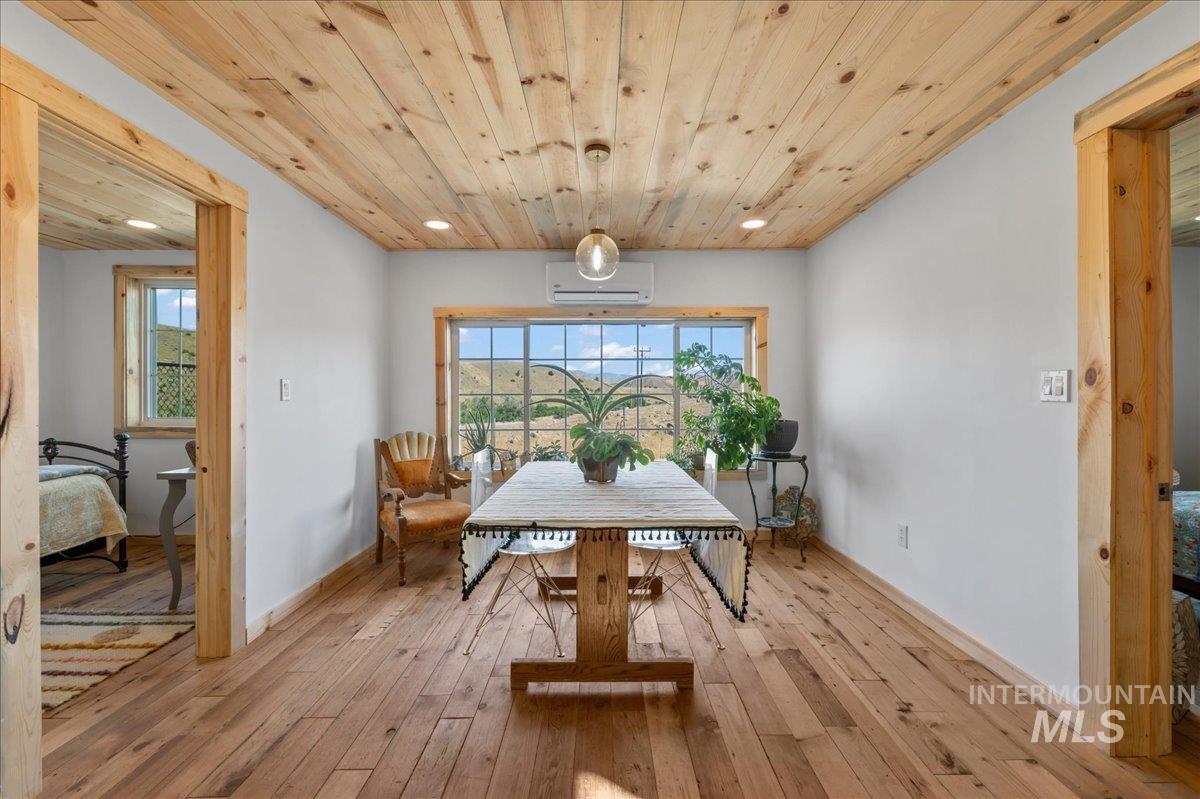 ADU dining space featuring light wood finished floors, wooden ceiling, recessed lighting, a wall mounted heat/AC mini split, and healthy amount of natural light and amazing views of the river and mountains