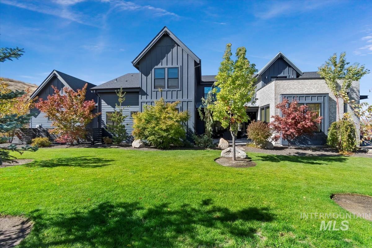 Back of house with board and batten siding and a lawn