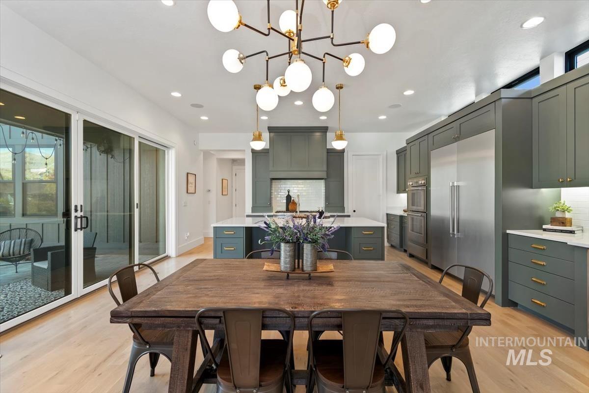 Dining space with light wood finished floors, recessed lighting, and a chandelier
