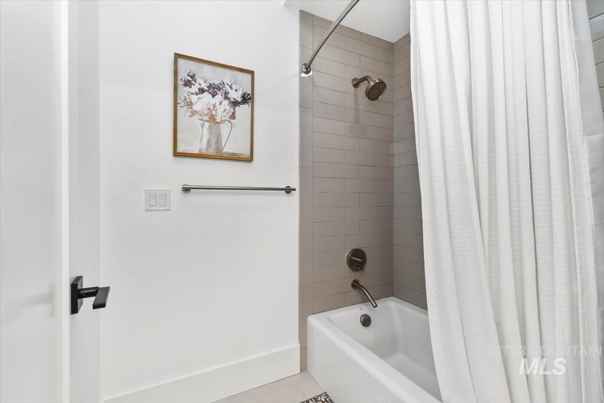 Full bathroom with shower / tub combo and tile patterned floors