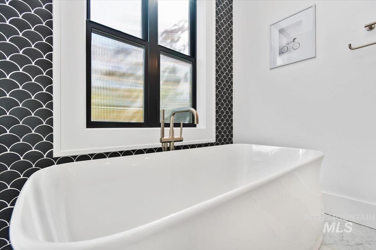 Full bathroom featuring a freestanding bath and a sink