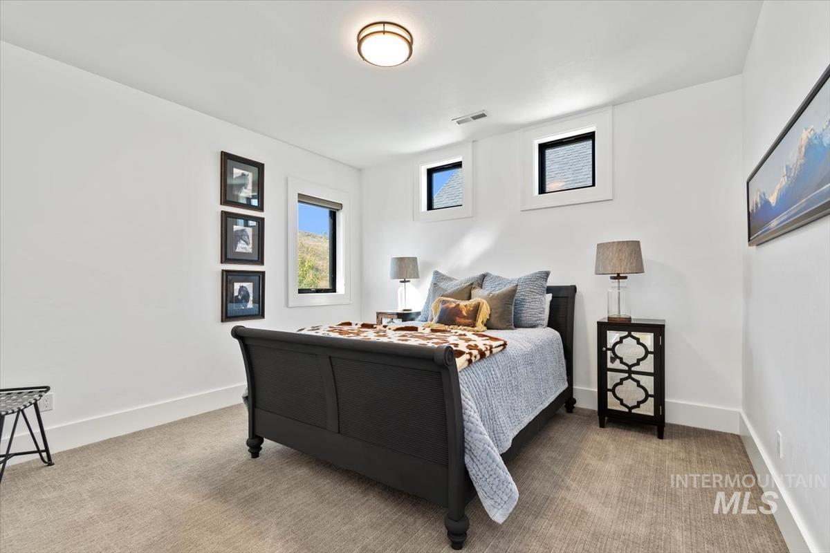 Bedroom featuring baseboards and light colored carpet