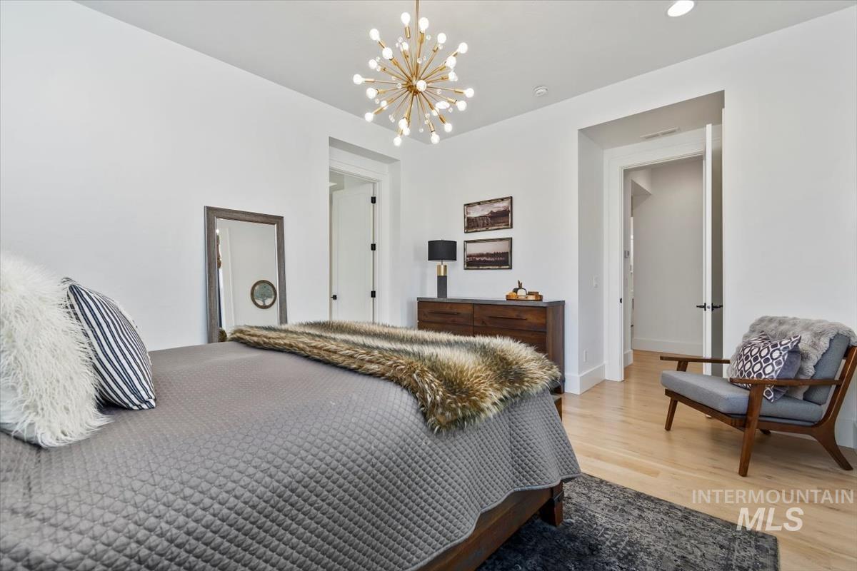 Bedroom with a chandelier, light wood-style flooring, and recessed lighting