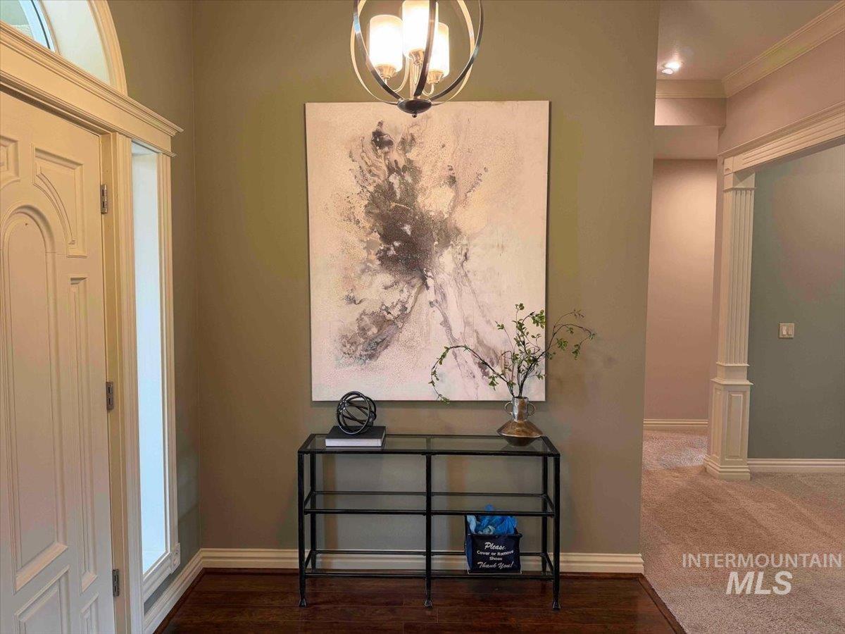Foyer entrance with dark wood-type flooring and ornamental molding
