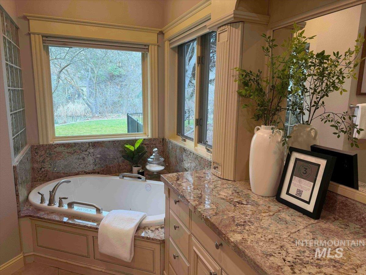 Bathroom featuring a garden tub and vanity