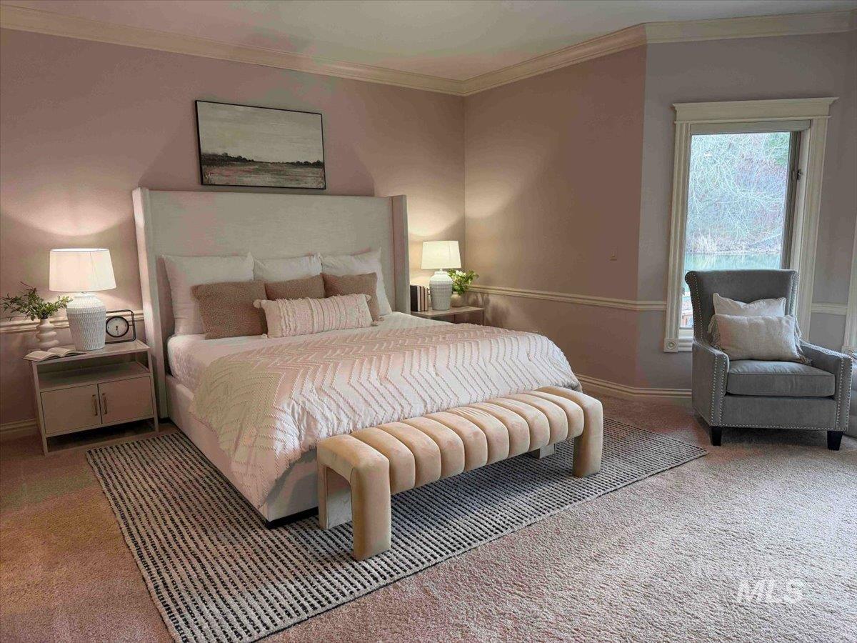 Carpeted bedroom featuring crown molding and baseboards