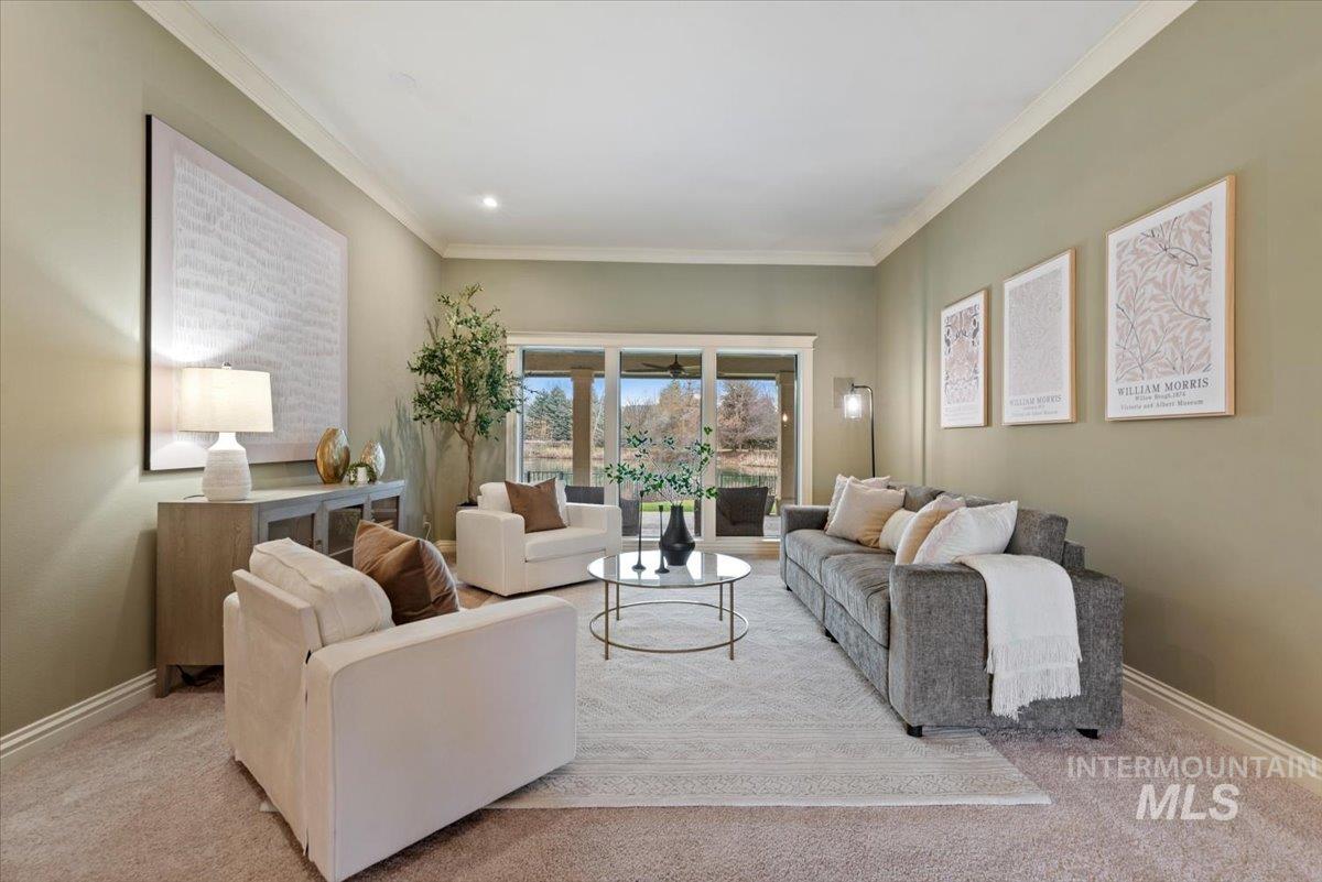 Living room with ornamental molding and light carpet