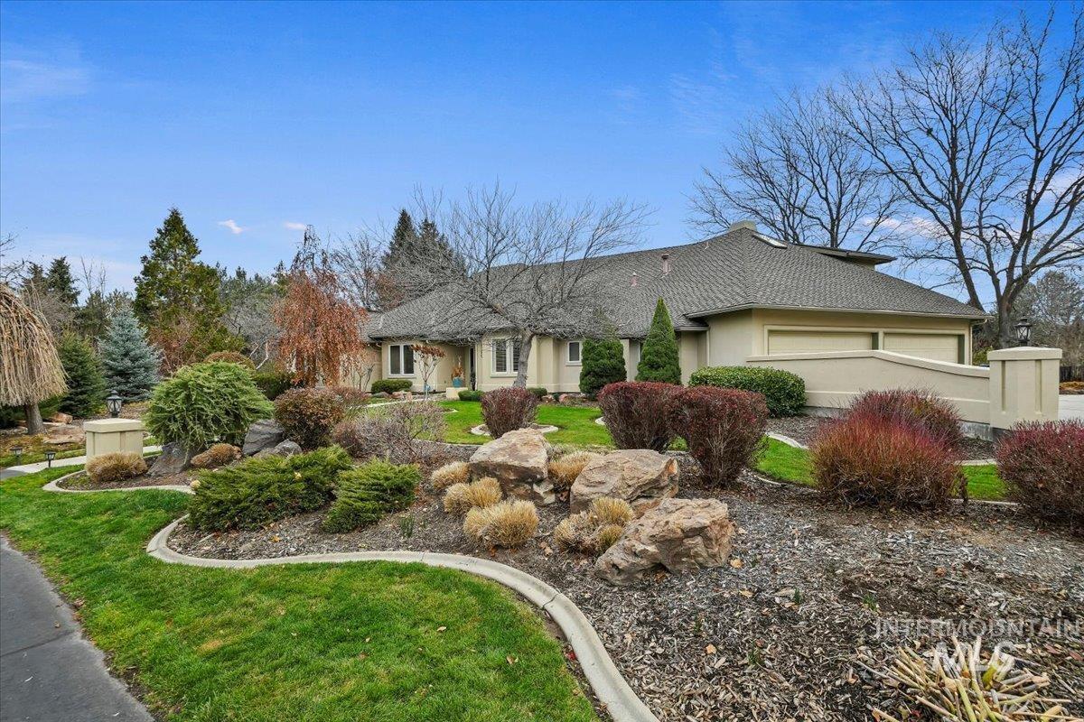 Ranch-style house featuring a garage, a front yard, and stucco siding