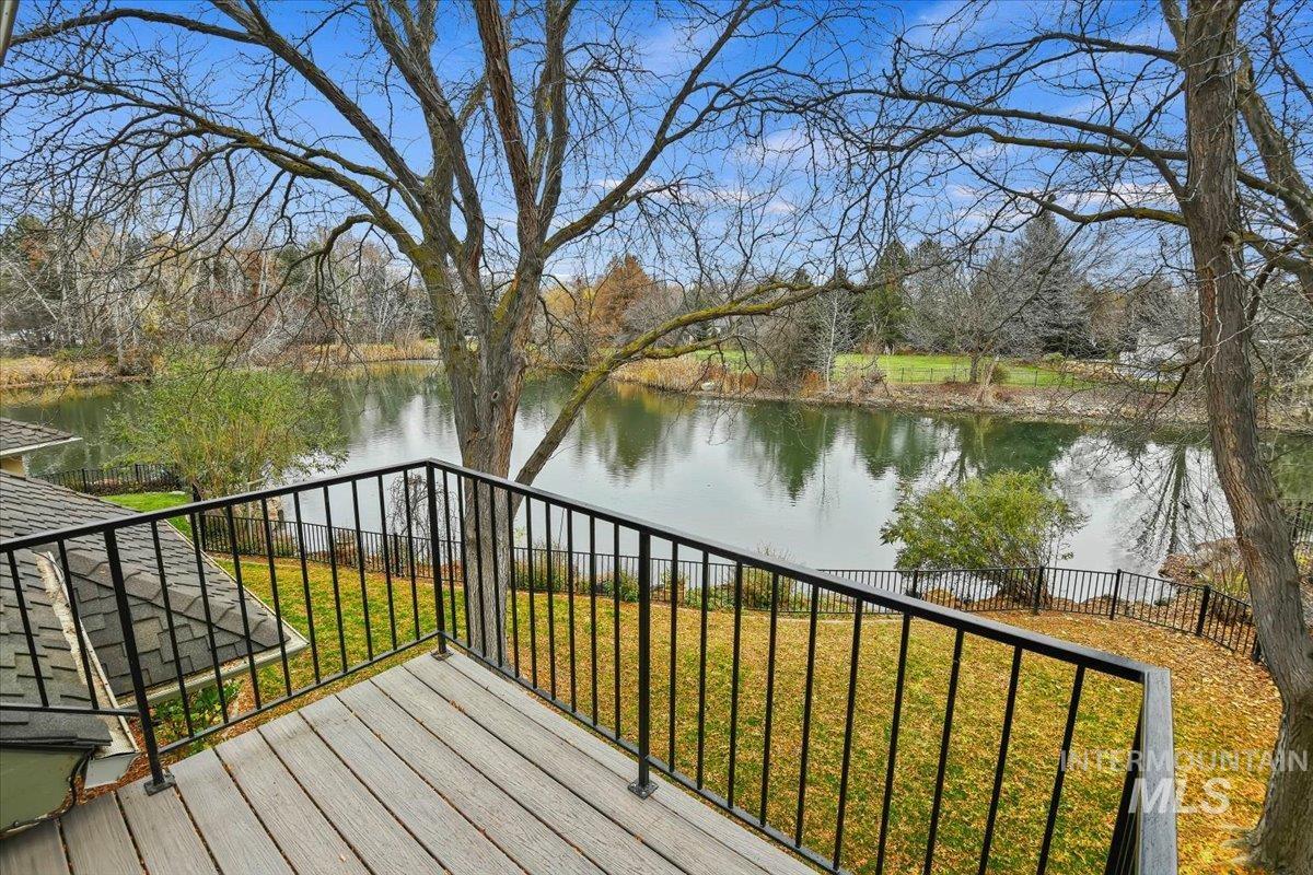 Wooden deck with a water view and a yard