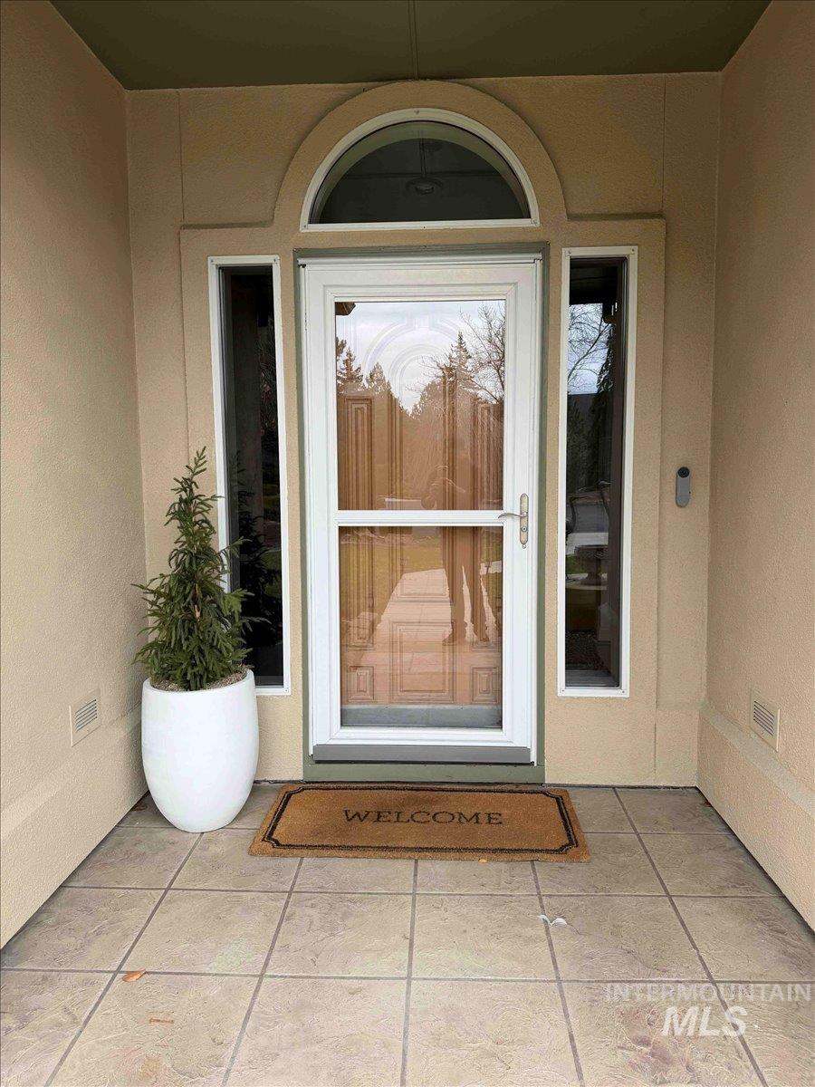 View of exterior entry featuring stucco siding