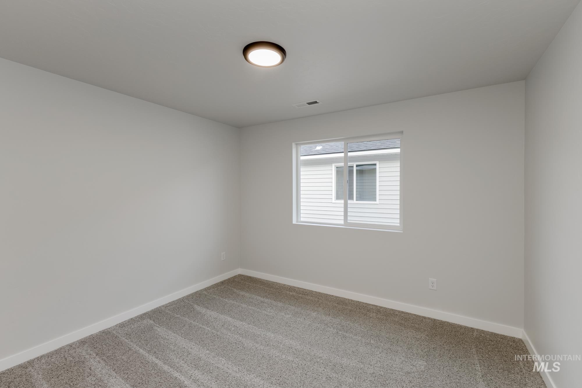 Empty room with carpet flooring and baseboards