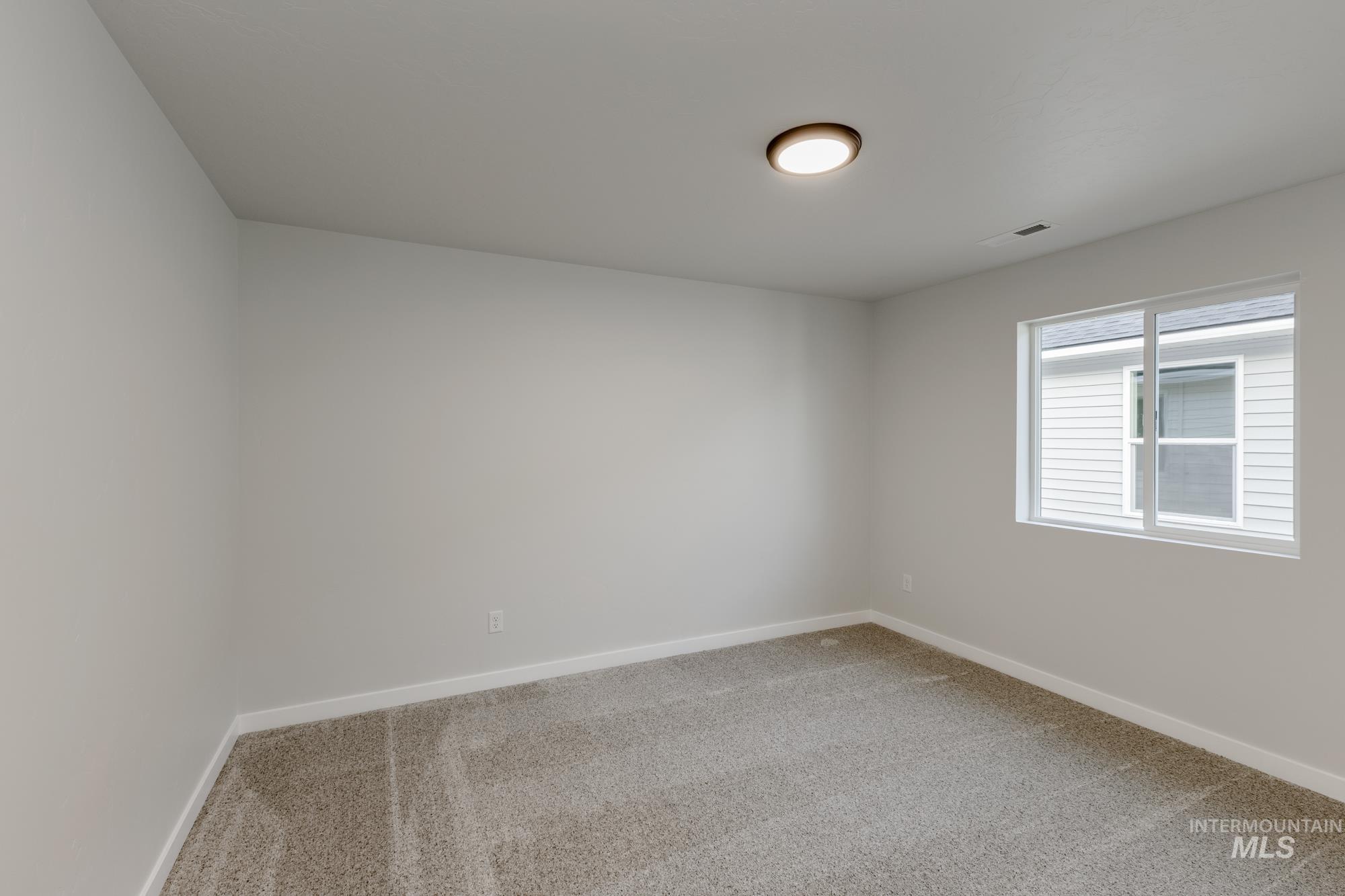 Empty room with light carpet and baseboards