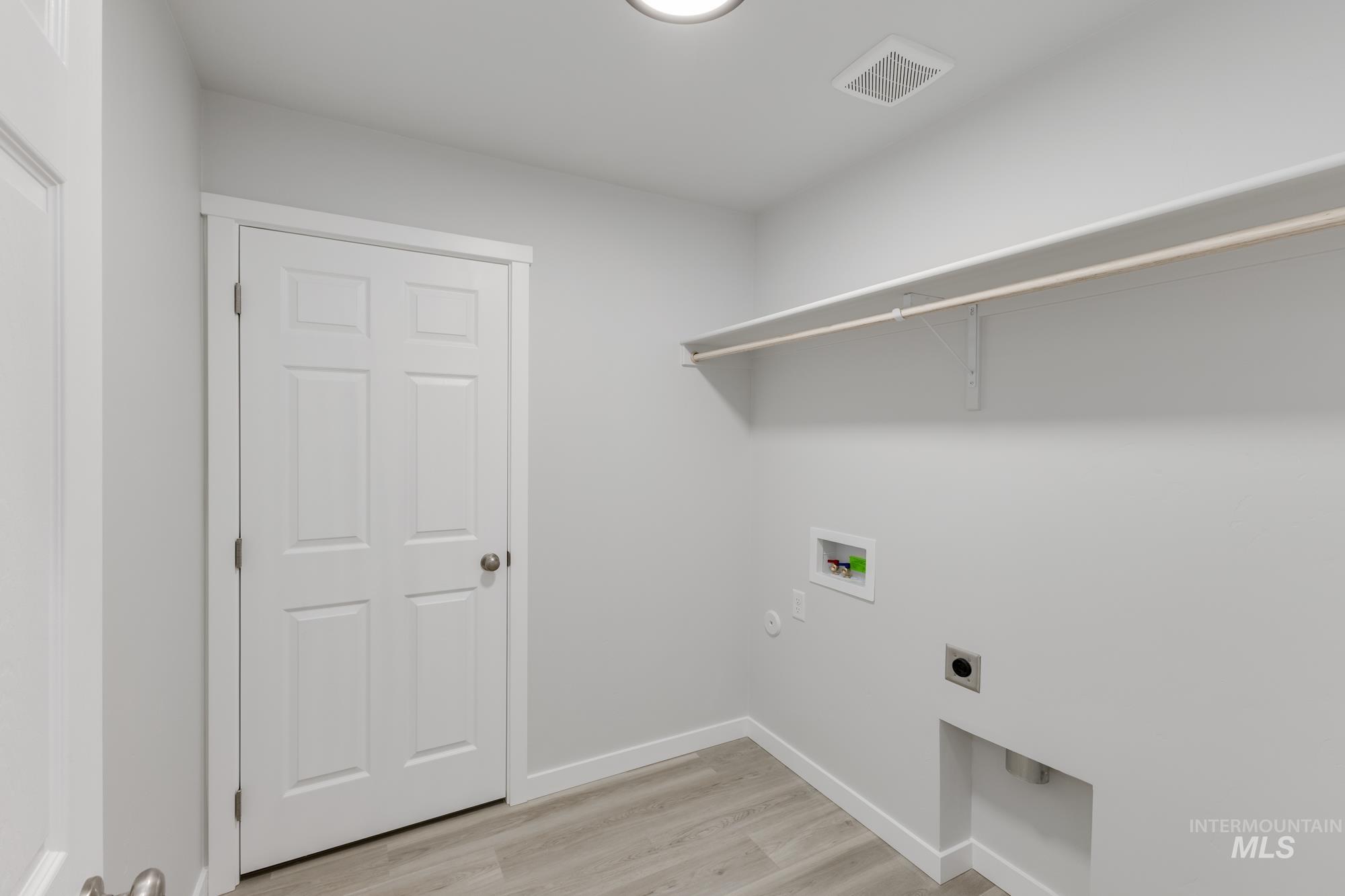 Laundry room with light wood-style floors, washer hookup, electric dryer hookup, and gas dryer hookup