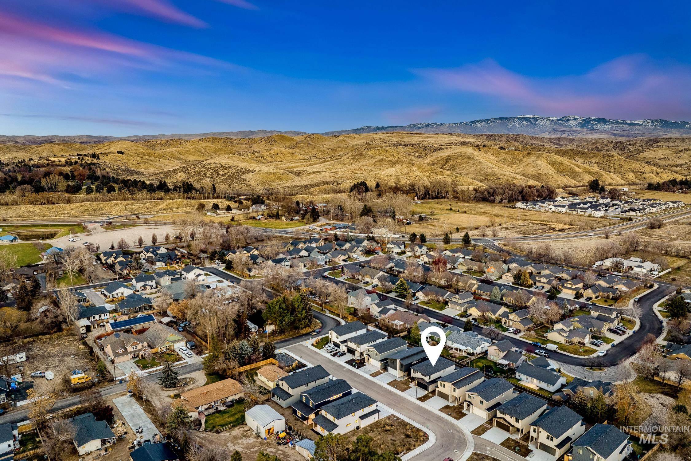 Aerial view of property's location featuring nearby suburban area and a mountainous background
