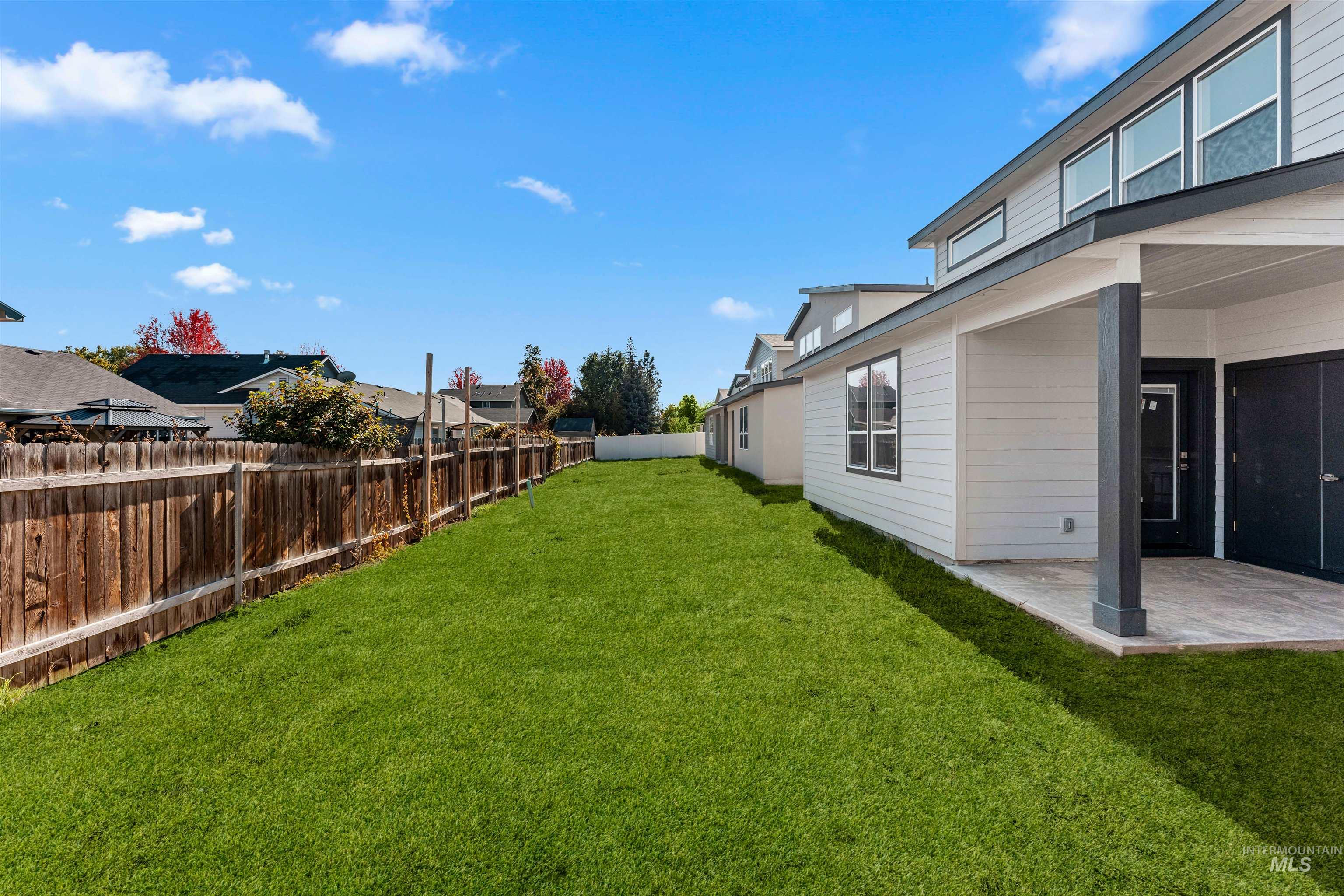 Fenced backyard featuring a patio area and a residential view