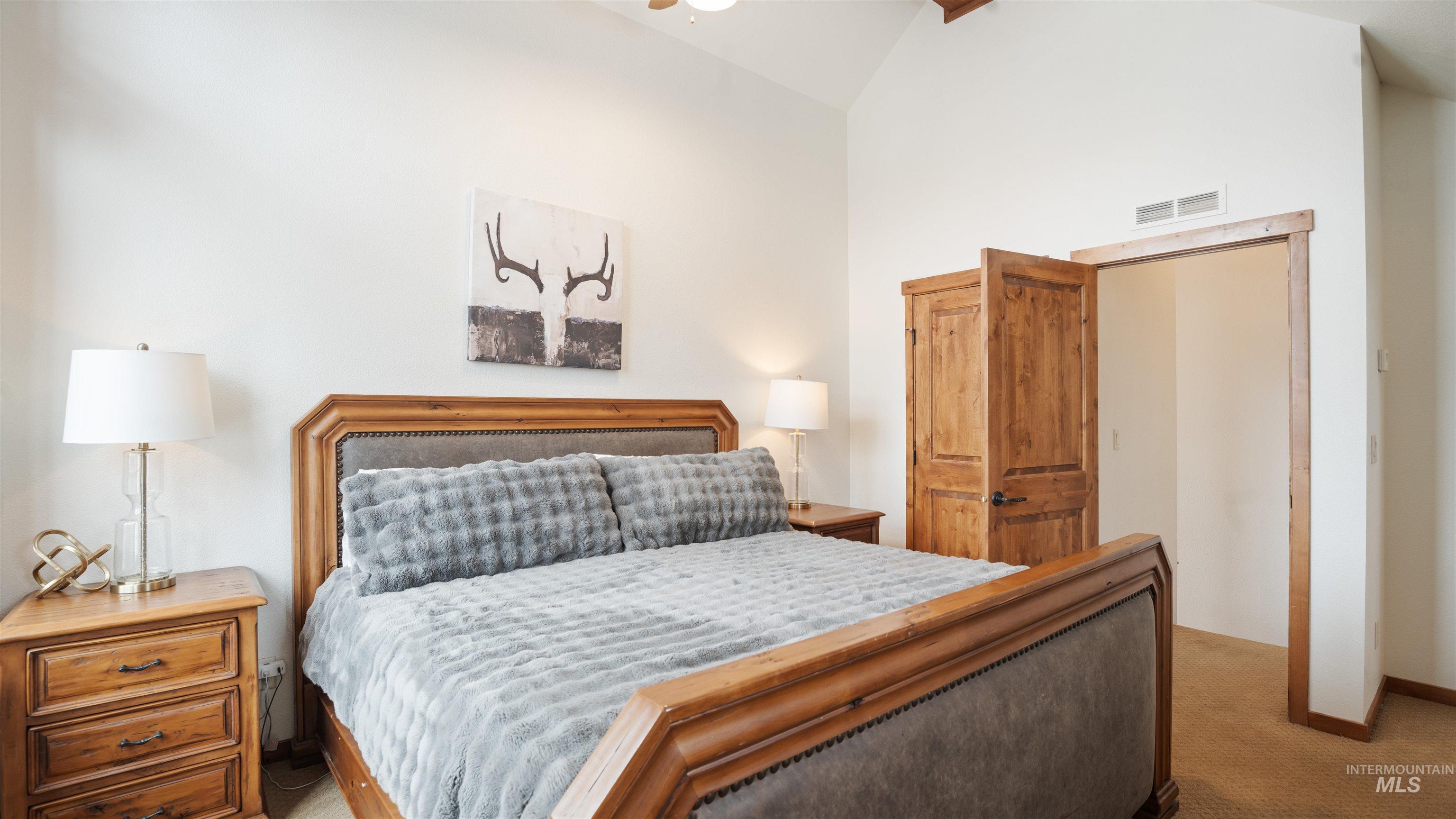 Bedroom featuring carpet floors and vaulted ceiling