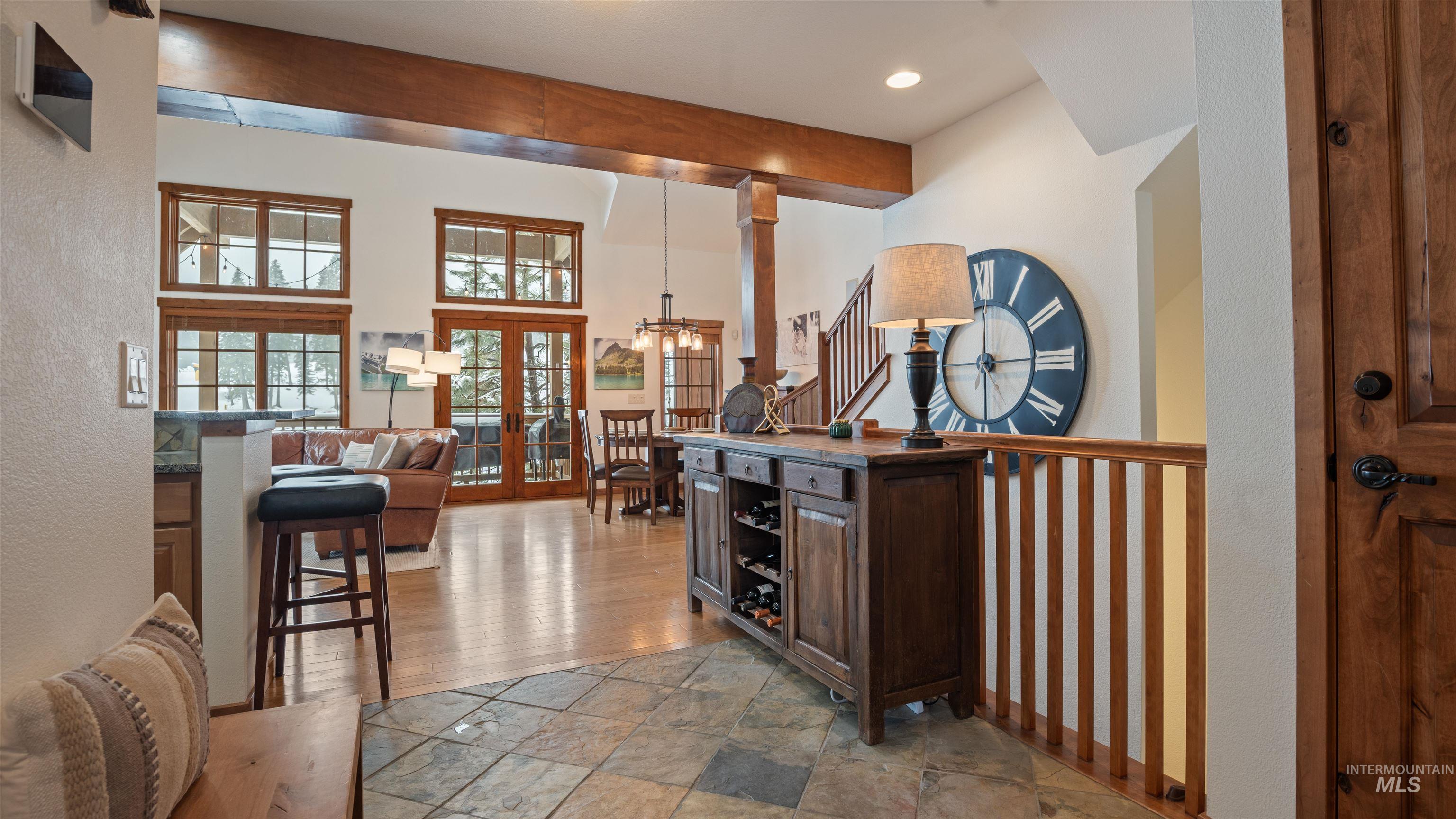 Foyer with french doors, a high ceiling, light stone finish flooring, and recessed lighting