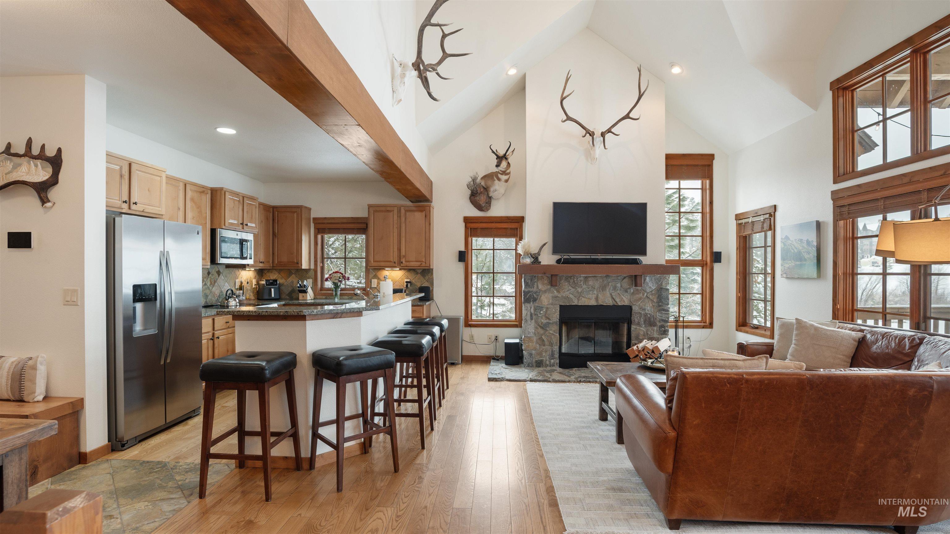 Living area with light wood-style floors, a fireplace, recessed lighting, and lofted ceiling