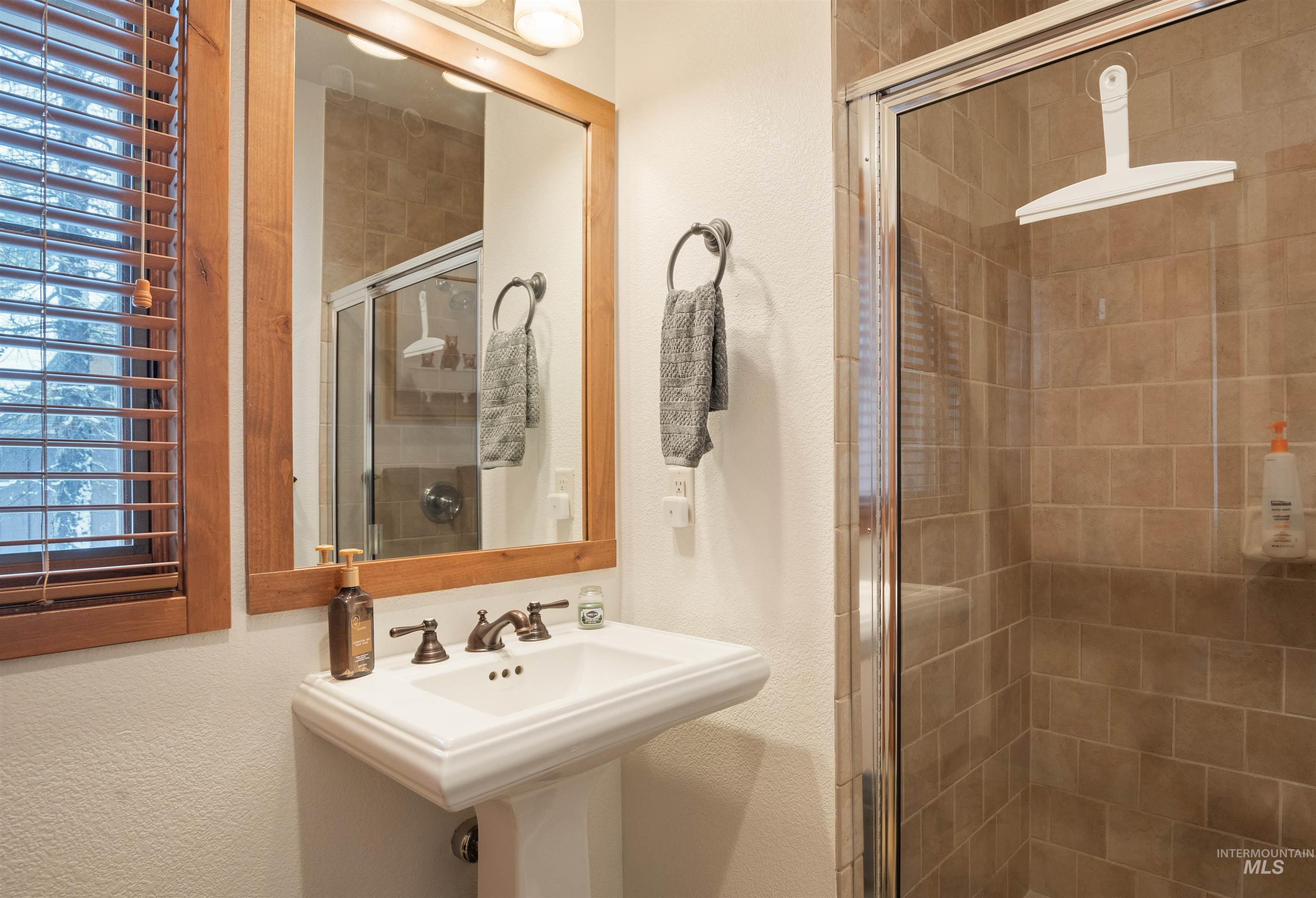 Full bath with a textured wall and a stall shower