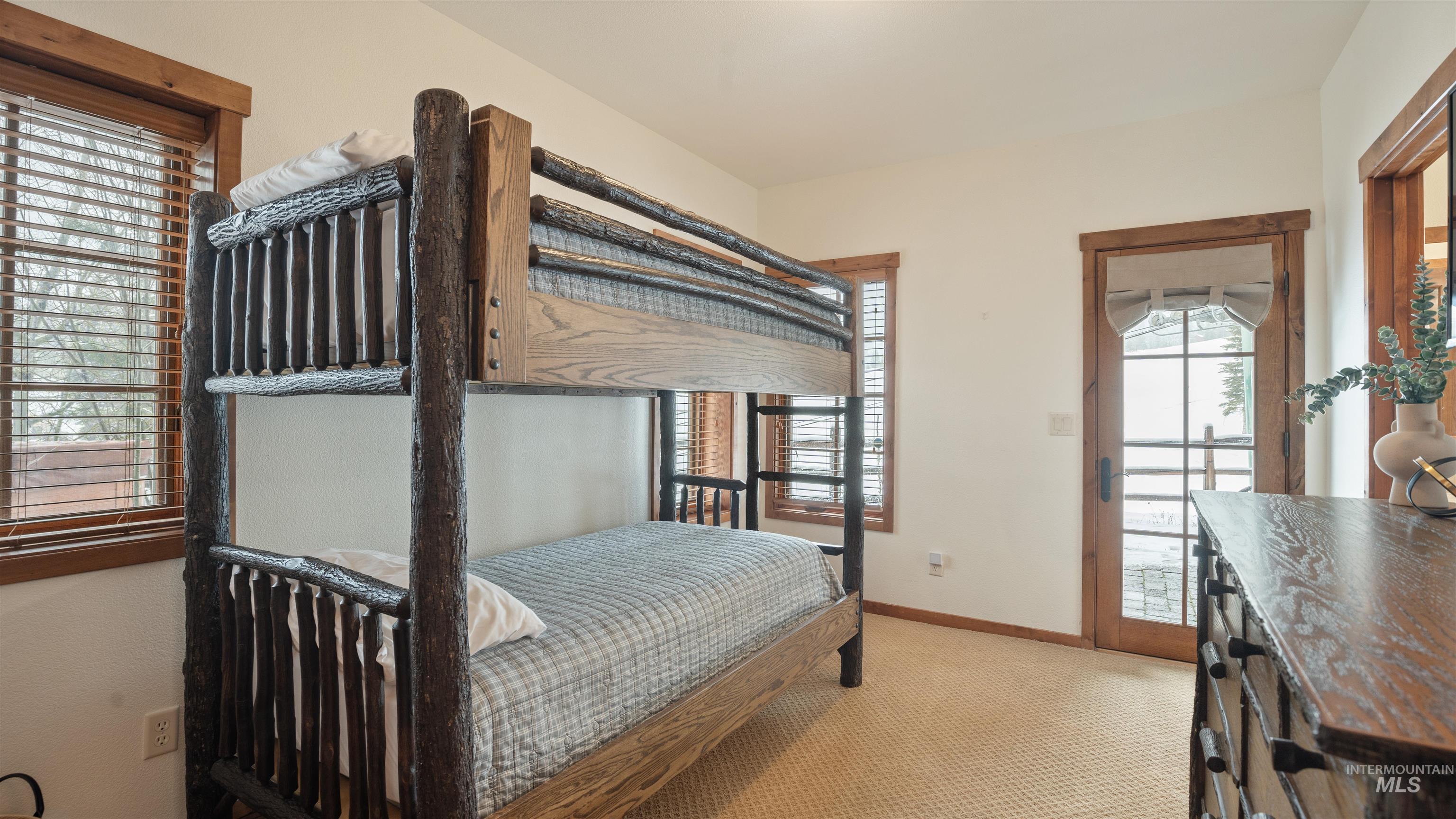 Bedroom featuring light carpet and baseboards